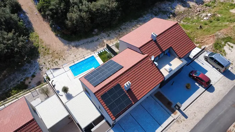 Solarna elektrana na krovu kuće s bazenom, snimljeno iz zraka